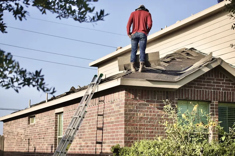Professional roofer working on a residential roof in Fort George G Meade